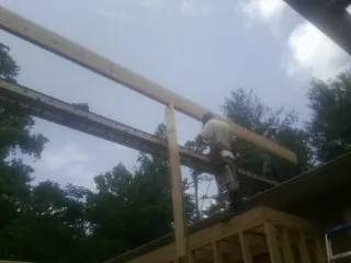Carpenter setting a ridge beam over a new addition frame — Ice Dam Removal by Roofing Brothers in San Quentin