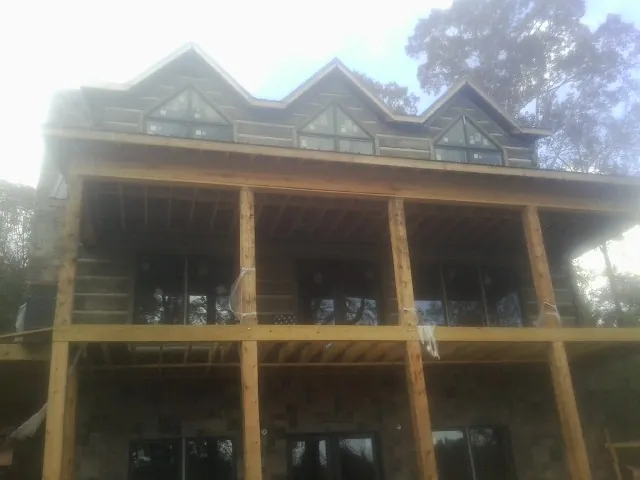 Dormers and porch framing on a large log home under construction — Roof Coating work by our crew in San Quentin