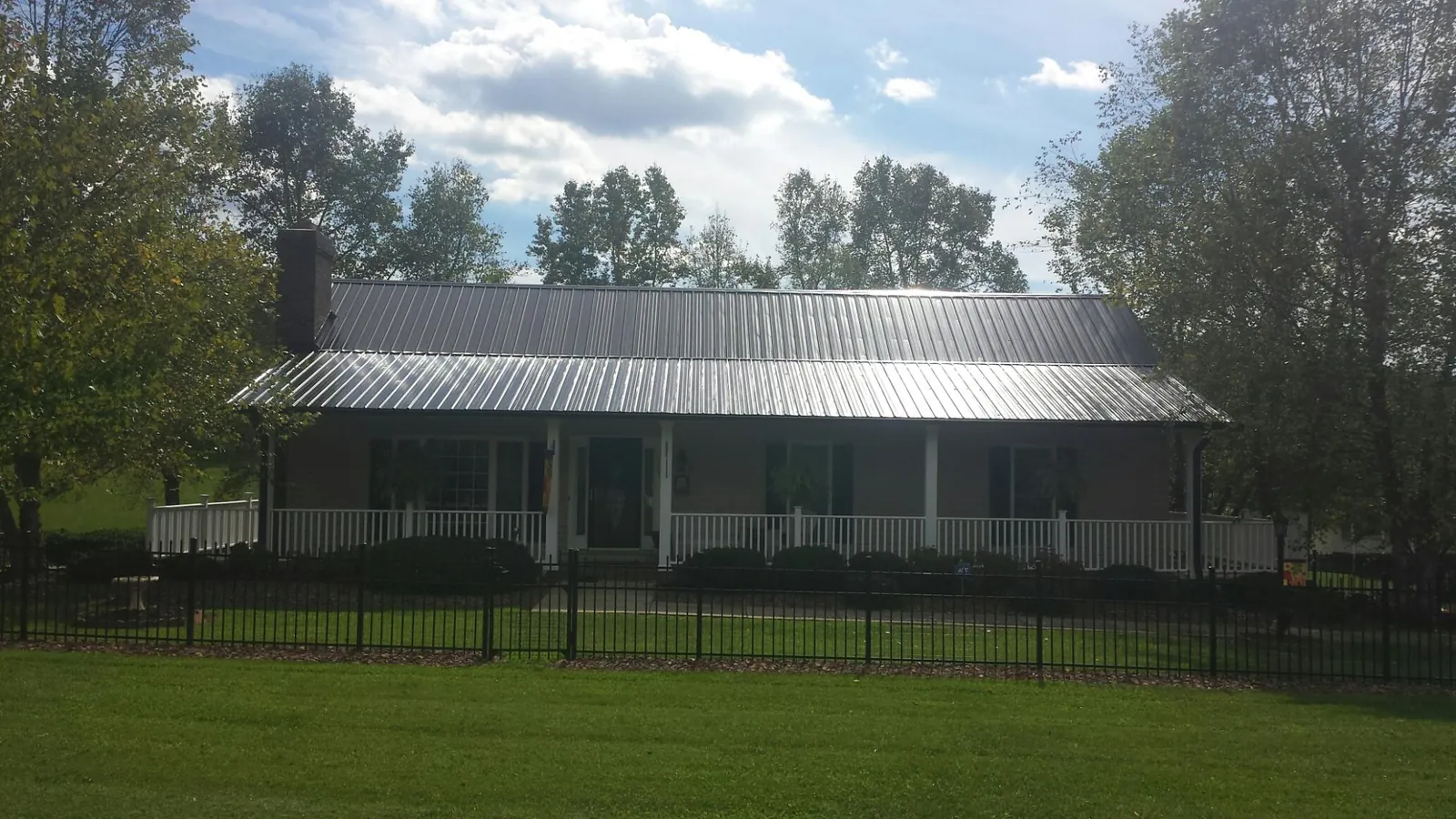 Gray metal roof on a brick ranch with a full width front porch — Gutter Guard Installation work by our crew in San Quentin